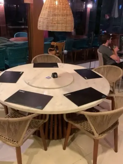 Mesa de restaurante sofisticado com cadeiras de vime e luminária